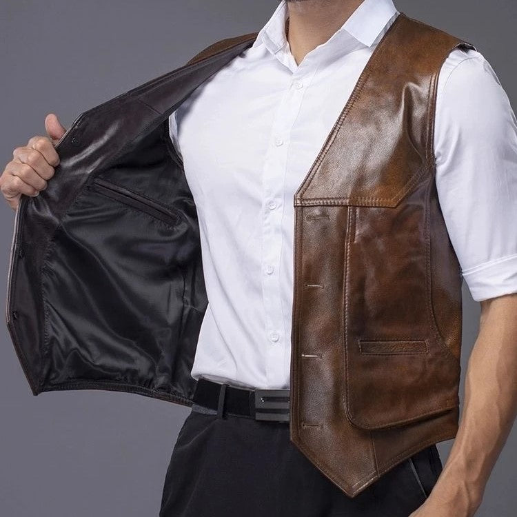 A man wearing a brown cowhide leather motorcycle vest on top of a white short sleeve polo shirt, showing the inside of the right side of the vest and pair of dark blue pants.