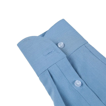 The sleeve and cuff of a man's light blue button down dress shirt.