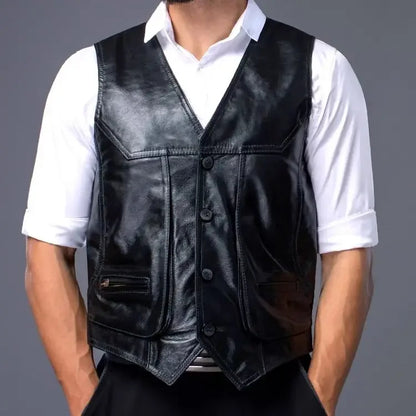 A man wearing a black cowhide leather motorcycle vest on top of a white short sleeve polo shirt, hands in pockets and pair of dark blue pants.