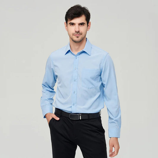 A front view of a man standing, wearing a light blue button up dress shirt, dark blue pants and a black belt.